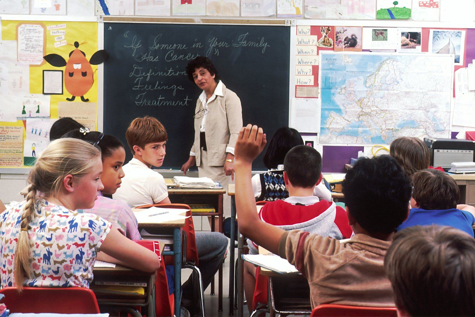 Students raising their hands in a classroom